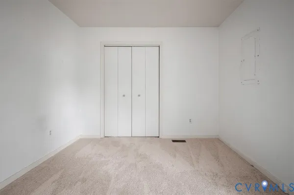 an empty room with windows and closet