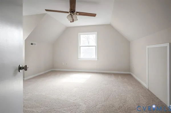 an empty room with fan and windows