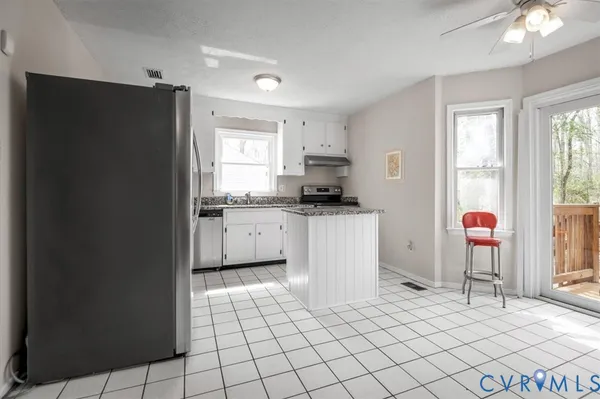 a kitchen with a sink a refrigerator and cabinets
