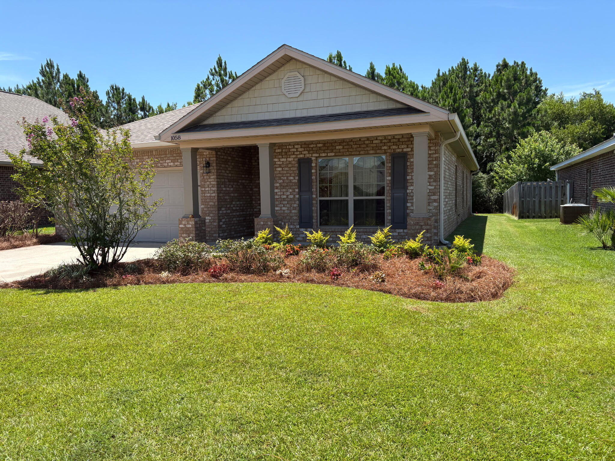 a front view of a house with a garden and plants