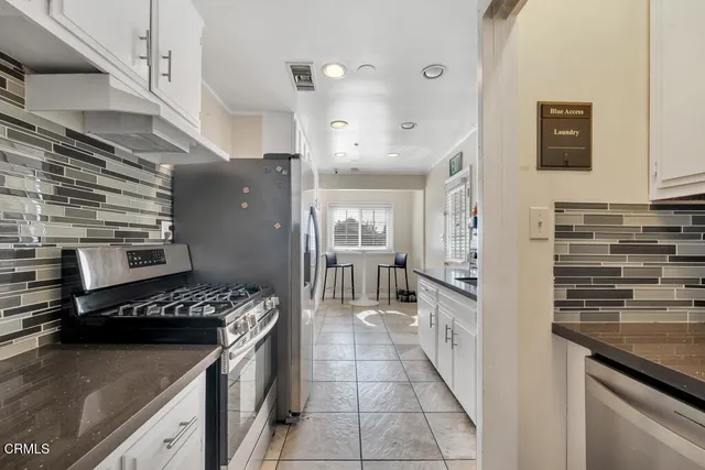 a kitchen with stainless steel appliances granite countertop a stove and a refrigerator