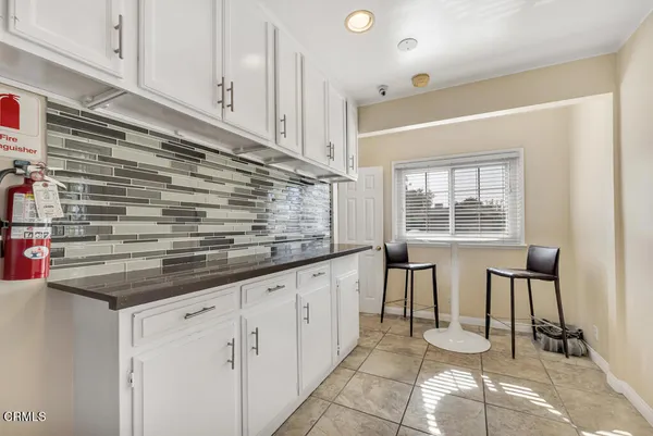 a kitchen with granite countertop white cabinets and white appliances