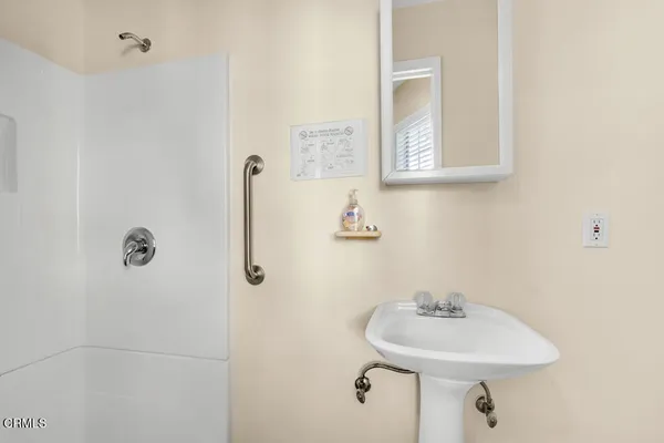 a bathroom with a sink a mirror and shower