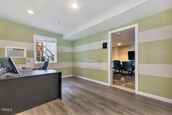a view of a kitchen with kitchen island a sink wooden floor and living room