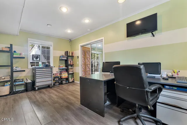 a view of a workspace with furniture and a flat screen tv