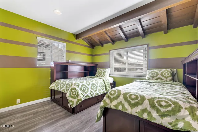 a bedroom with two beds and painting on the wall