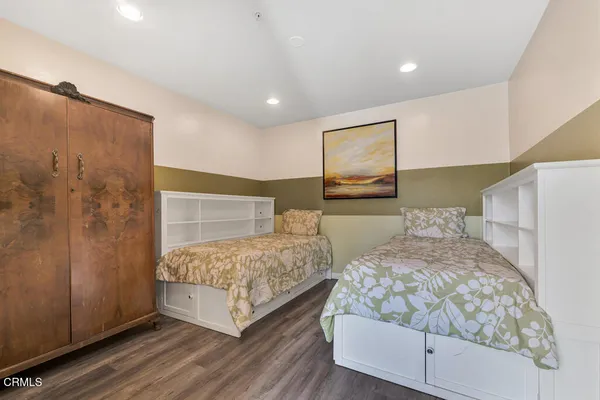 a bedroom with two beds and painting on the wall