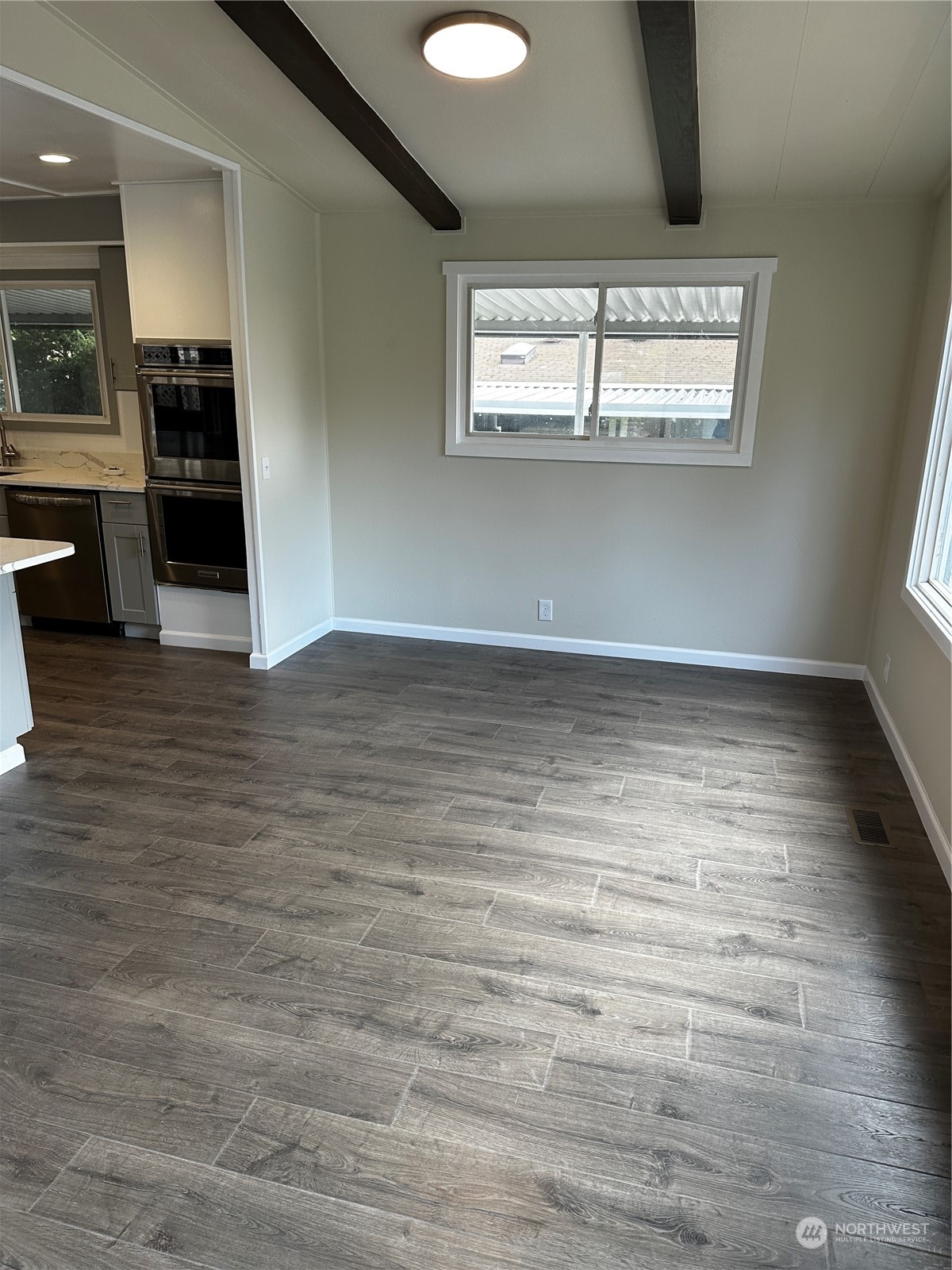 201 Union Avenue Southeast, Unit 90 Renton, WA 98059 - Photo 5 of 22 an empty room with wooden floor and windows