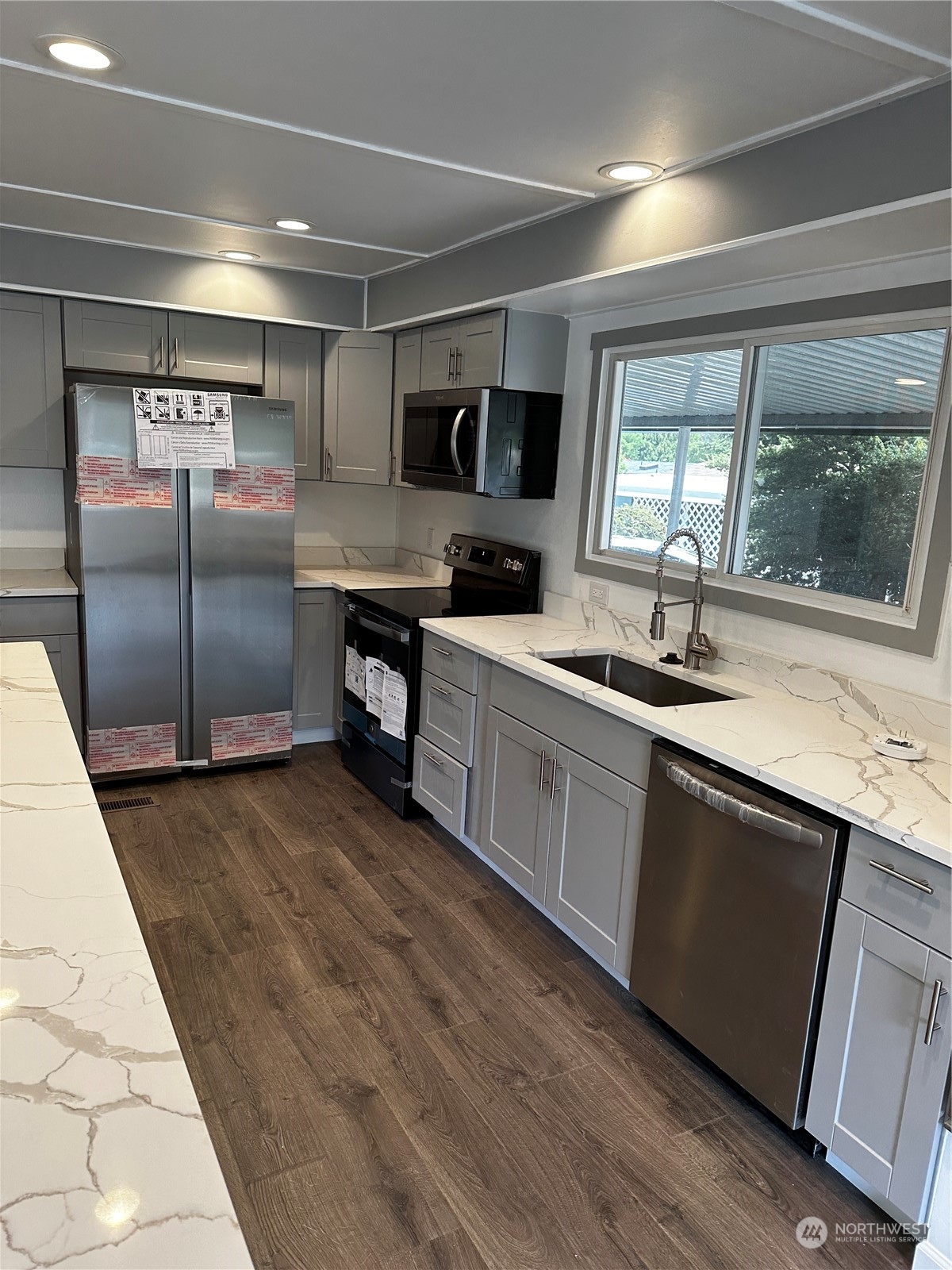 201 Union Avenue Southeast, Unit 90 Renton, WA 98059 - Photo 8 of 22 a kitchen with stainless steel appliances granite countertop a sink and wooden cabinets