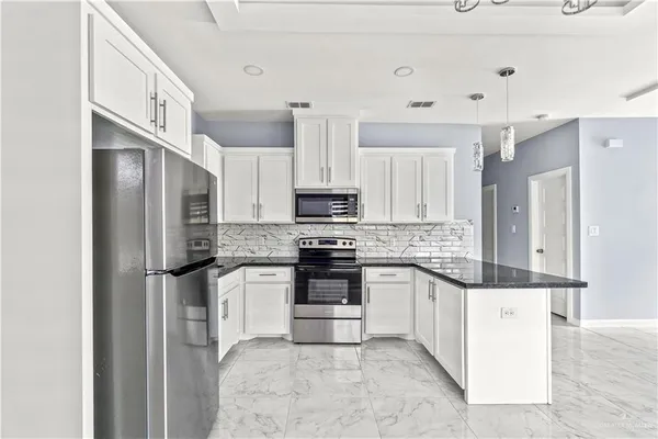 a kitchen with stainless steel appliances granite countertop a refrigerator a stove and a sink