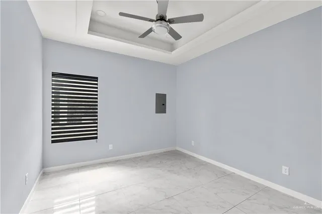 an empty room with windows and ceiling fan