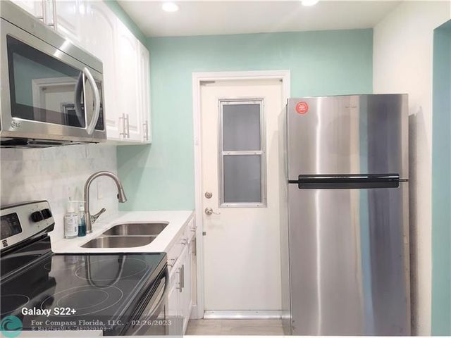 a kitchen with a refrigerator and a sink