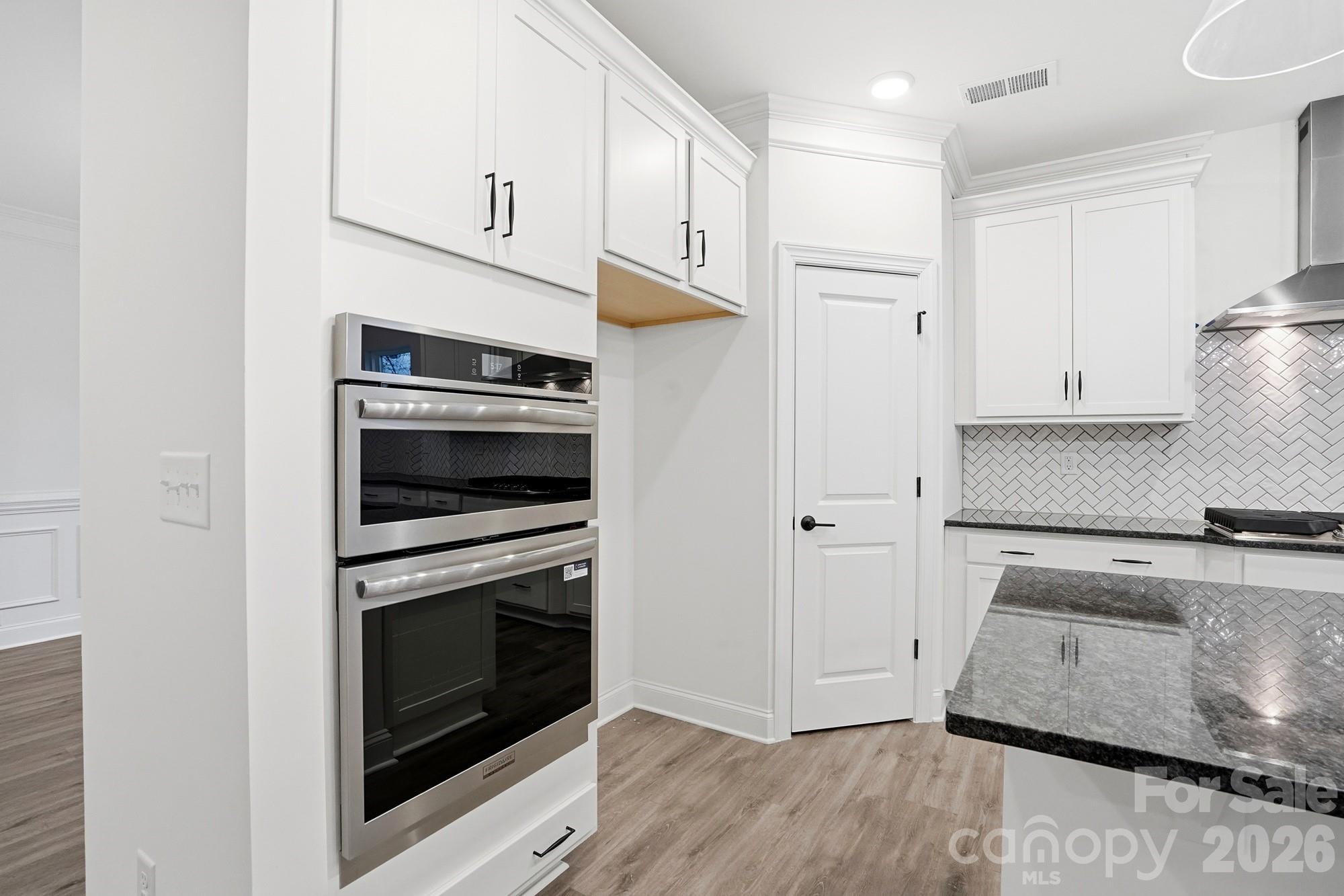 5072 Mclaughlin Loop Waxhaw, NC 28173 - Photo 13 of 46 a kitchen with granite countertop white cabinets and stainless steel appliances