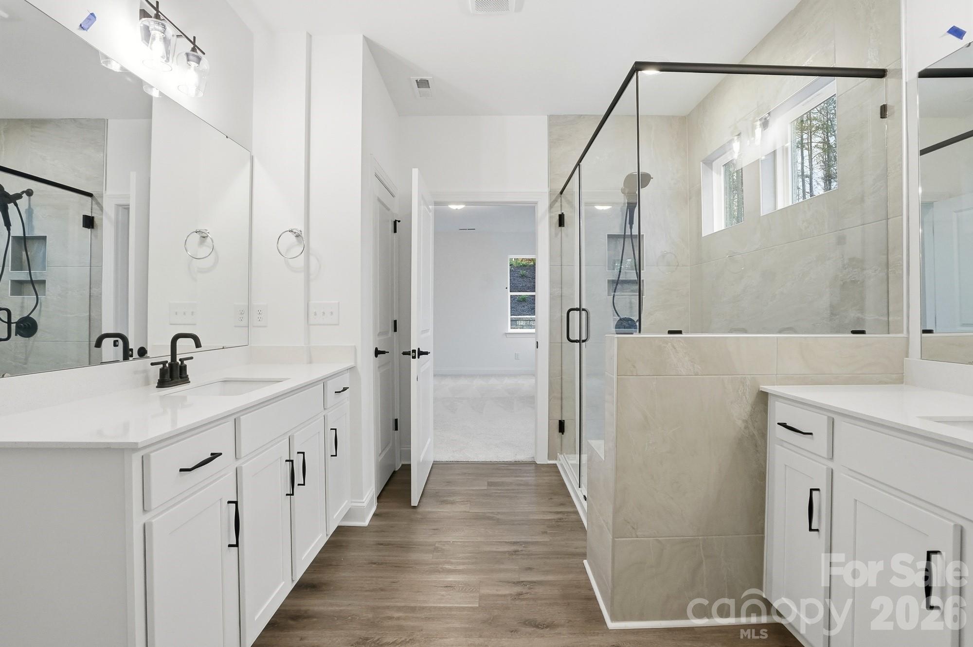 5072 Mclaughlin Loop Waxhaw, NC 28173 - Photo 22 of 46 a bathroom with a double vanity sink a toilet and a mirror
