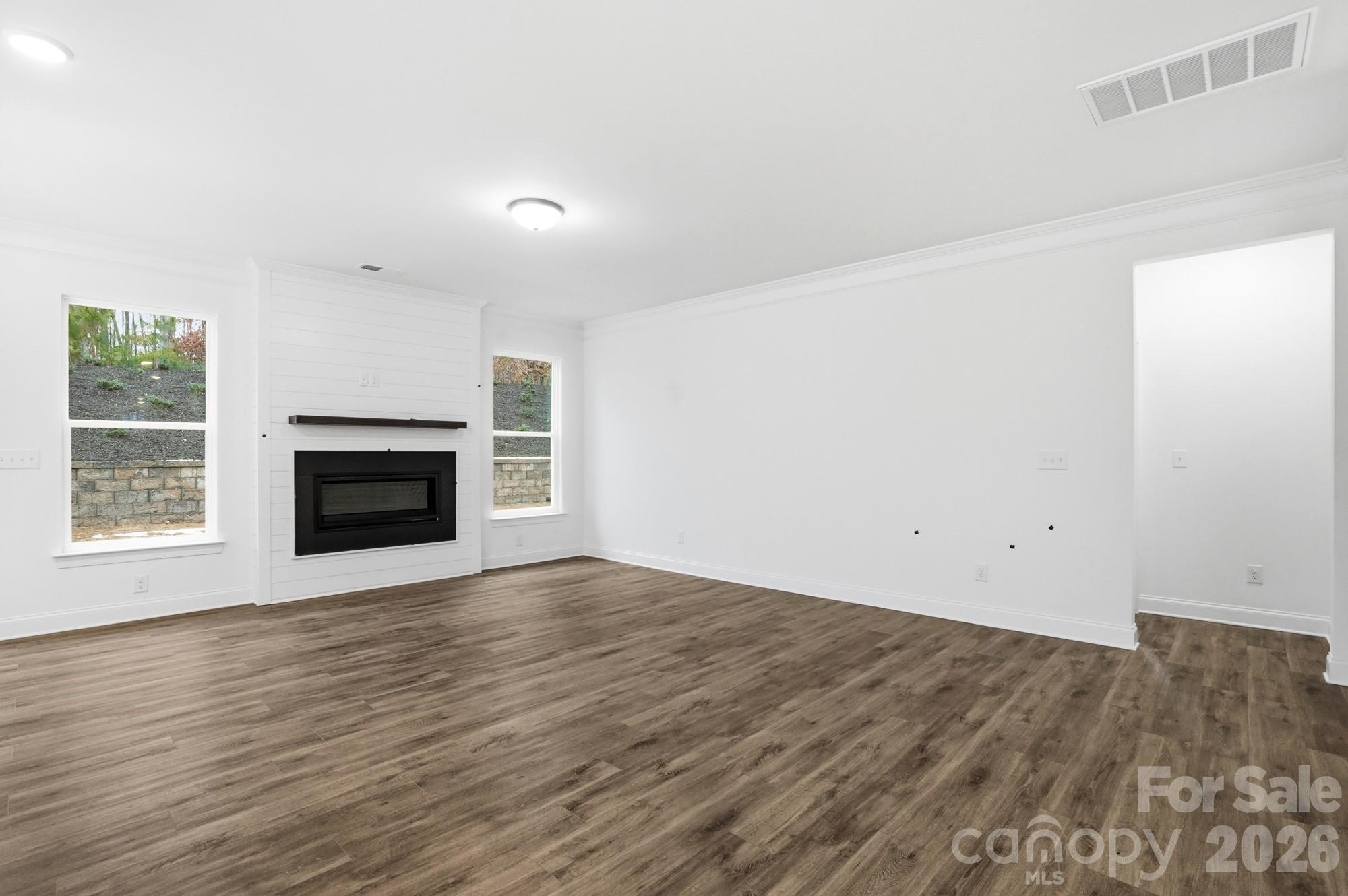 5072 Mclaughlin Loop Waxhaw, NC 28173 - Photo 6 of 46 an empty room with wooden floor a fireplace and windows