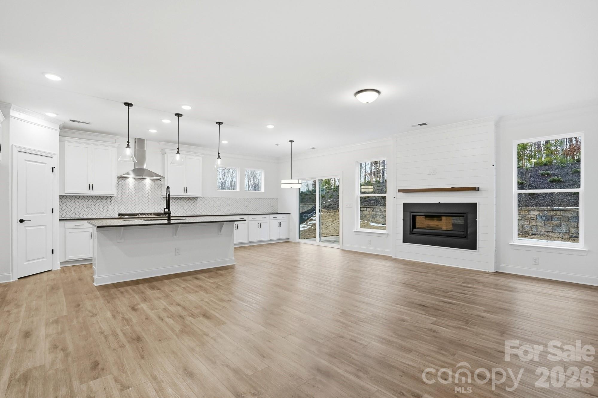 5072 Mclaughlin Loop Waxhaw, NC 28173 - Photo 7 of 46 a view of kitchen with kitchen island wooden floor and living room