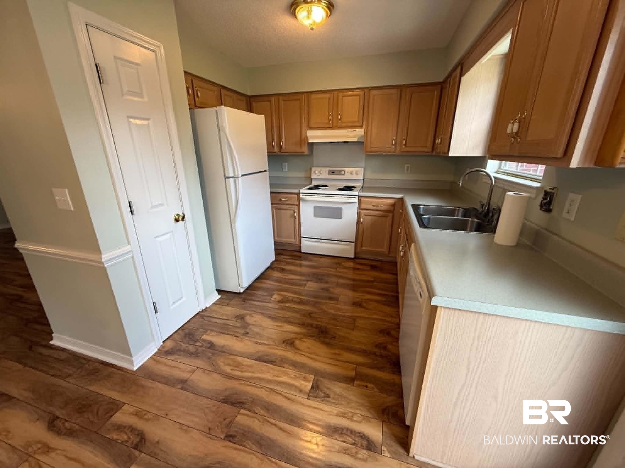 123 Pennbrooke Loop Foley, AL 36535 - Photo 27 of 49 Functional kitchen featuring wood-finish flooring, light wood cabinetry, and a double basin sink