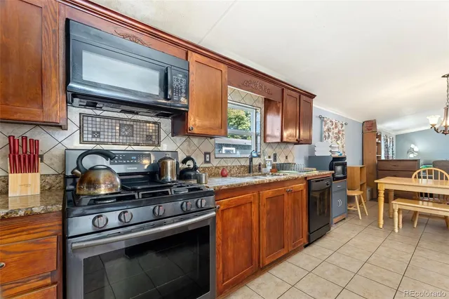 a kitchen with stainless steel appliances granite countertop a stove top oven a sink dishwasher and cabinets with wooden floor