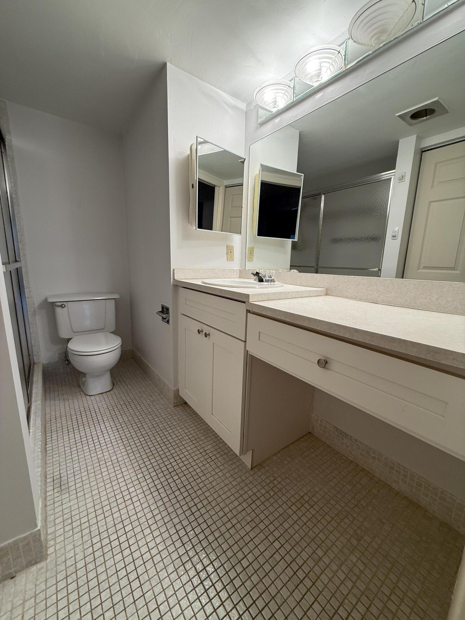 1043 Newcastle A Boca Raton, FL 33434 - Photo 12 of 17 a bathroom with a sink and mirror