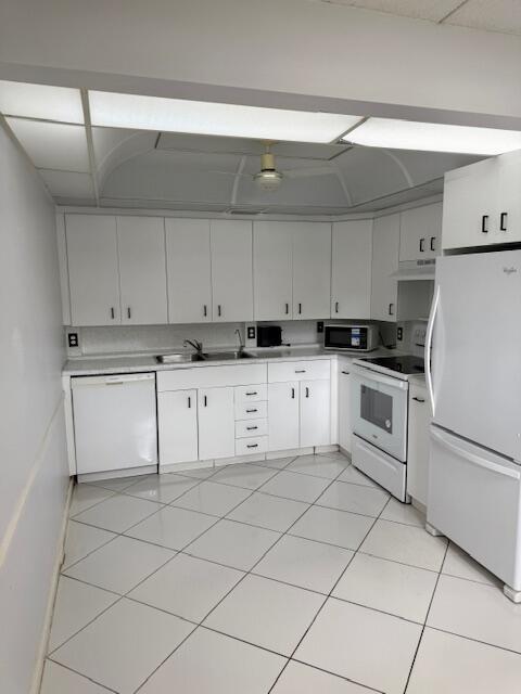 1043 Newcastle A Boca Raton, FL 33434 - Photo 3 of 17 a kitchen with granite countertop cabinets and white appliances