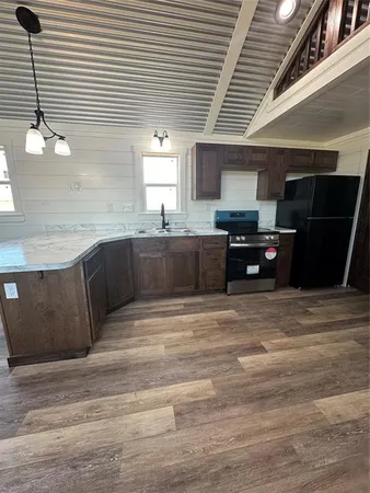 a large kitchen with granite countertop a stove and cabinets