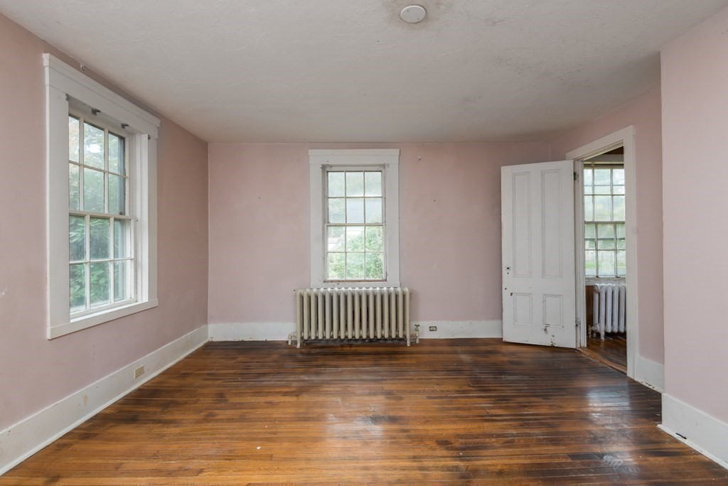 716 High Street Hanson, MA 02341 - Photo 9 of 21 an empty room with wooden floor and windows