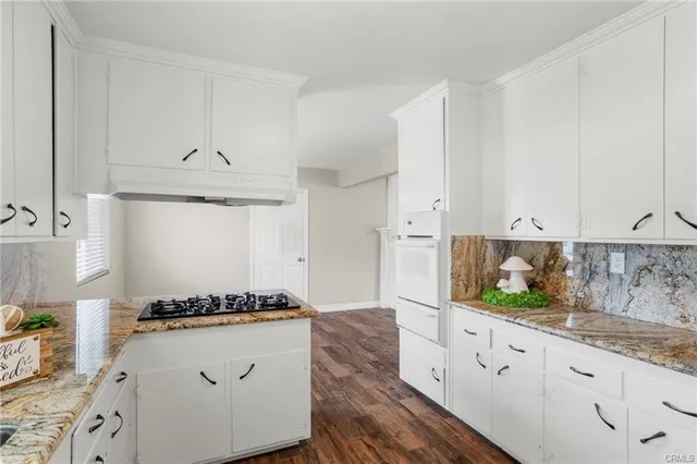 a kitchen with granite countertop white cabinets and white appliances