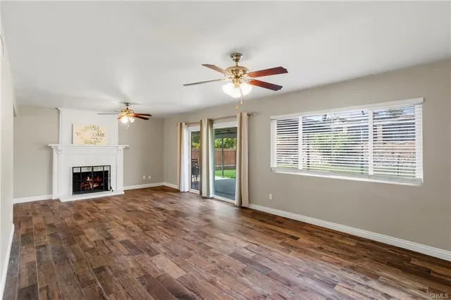 a view of an empty room with a fireplace and a window