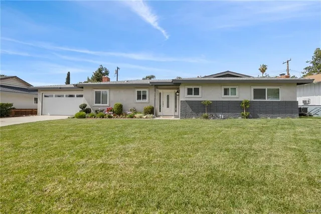 a front view of a house with a garden