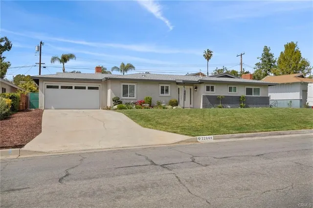 a view of a house with a yard and potted plants