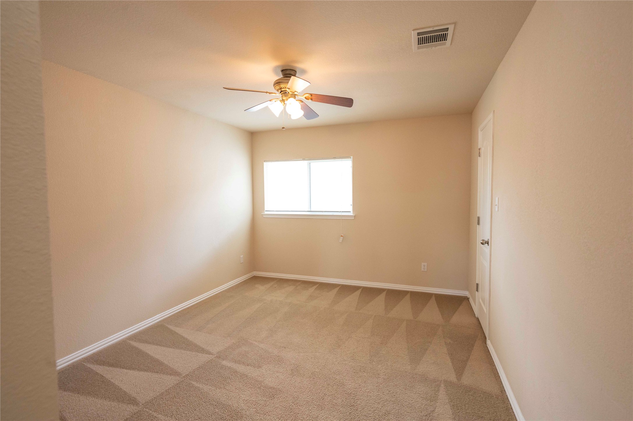 2070 Intrepid Drive Buda, TX 78610 - Photo 22 of 31 A well-lit bedroom features plush carpeting and a ceiling fan for comfort.