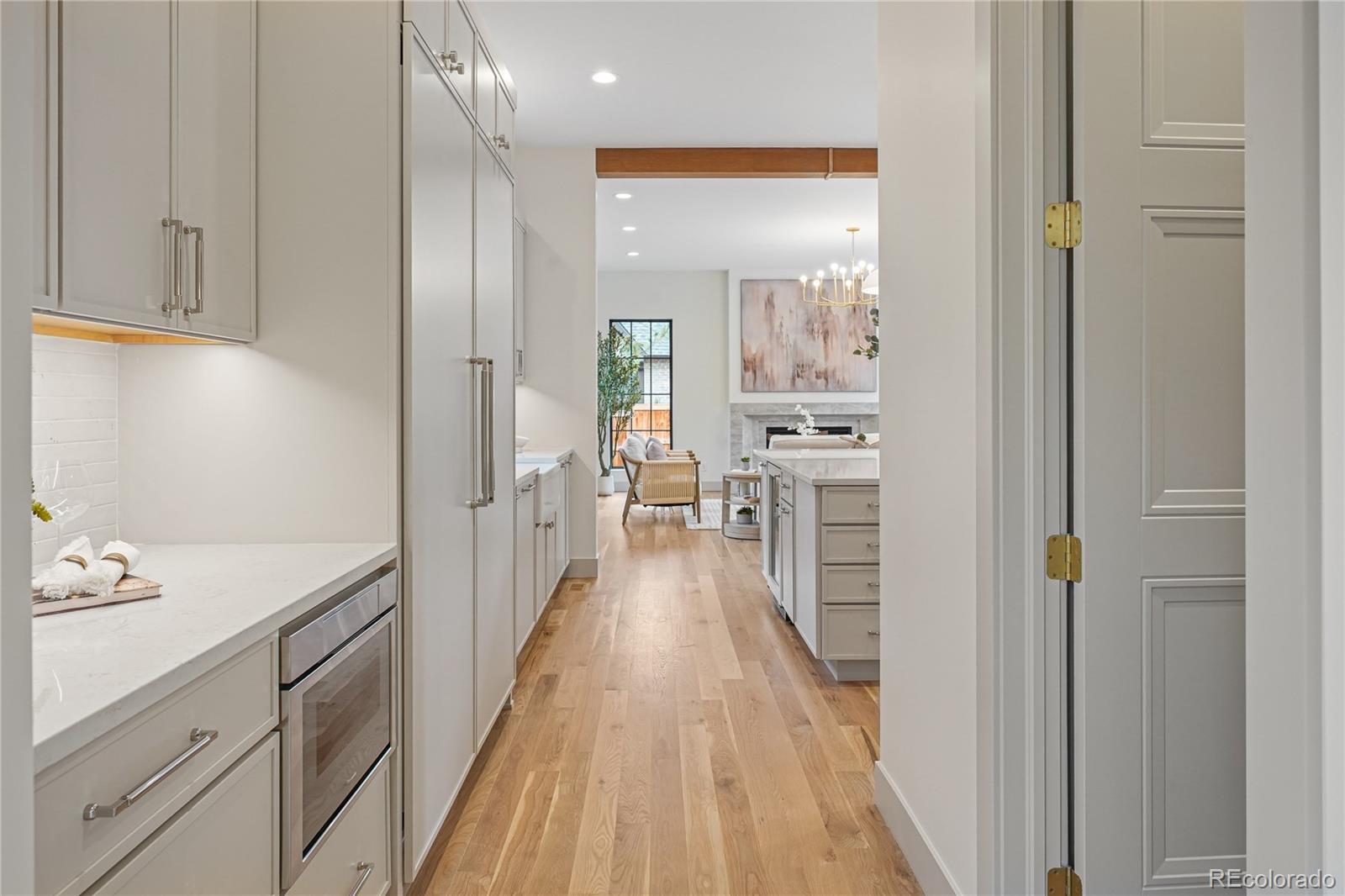 354 Cherry Street Denver, CO 80220 - Photo 10 of 44 a view of a kitchen with kitchen island white wooden cabinets and stainless steel appliances