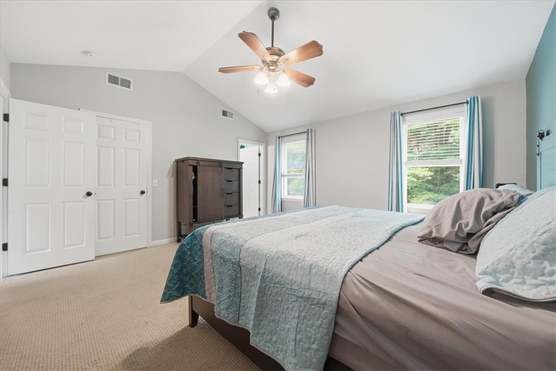26 Davis Circle Warwick, RI 02886 - Photo 29 of 50 Retreat upstairs to a stunning primary suite with soaring vaulted ceilings, a large walk-in closet, and a beautifully renovated bathroom.