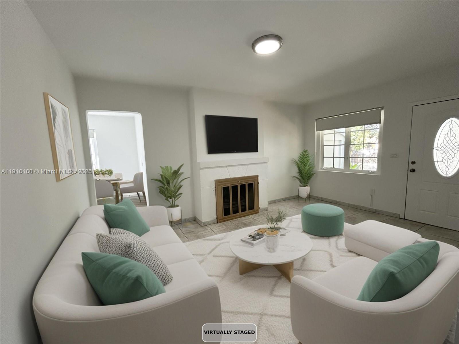 40 Northwest 39th Street, Unit 40 Miami, FL 33127 - Photo 2 of 17 a living room with furniture a fireplace and a flat screen tv