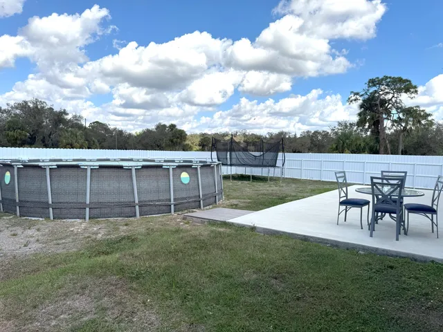 a view of a backyard with table and chairs