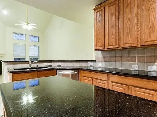a kitchen with stainless steel appliances granite countertop a sink a stove counter space and cabinets