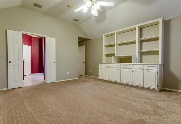 a view of an empty room with a cabinet and workspace