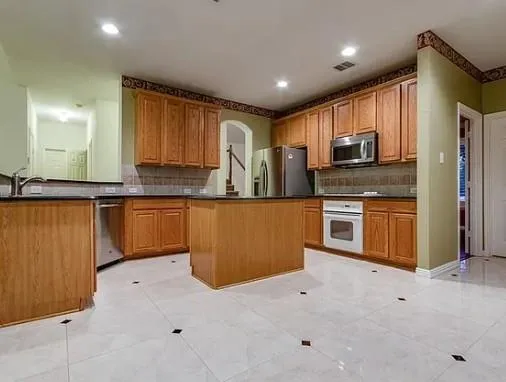 a kitchen with stainless steel appliances a refrigerator sink and microwave