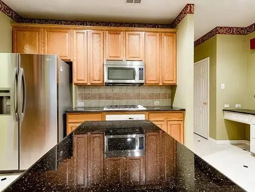 a kitchen with kitchen island a counter top space a sink and a refrigerator