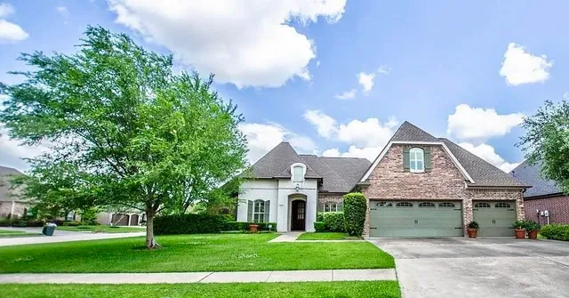 a front view of a house with a garden and trees