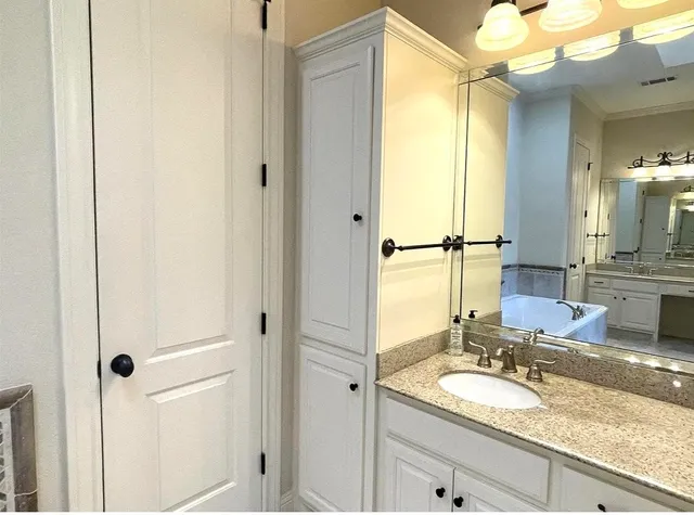 a bathroom with a granite countertop sink and a mirror
