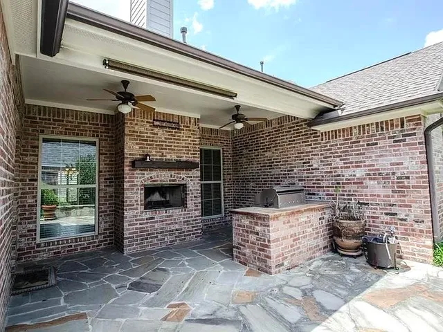 a front view of a house with barbeque grill and wooden floor