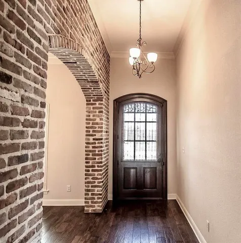 a view of a livingroom with a chandelier wooden floor and a chandelier