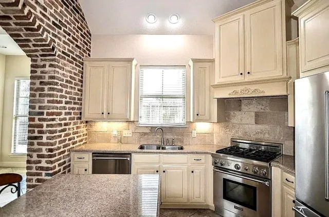 a kitchen with granite countertop a stove a sink and dishwasher