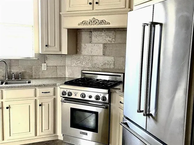 a kitchen with stainless steel appliances granite countertop a stove and a refrigerator