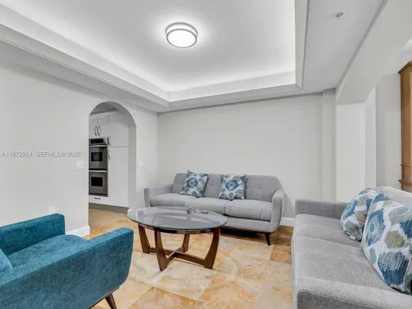 a living room with furniture and a stainless steel appliances