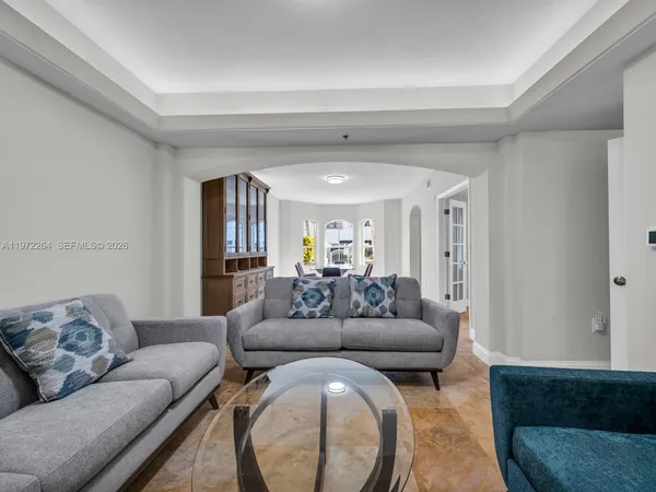 a living room with furniture and a view of kitchen