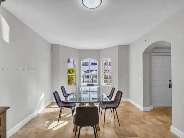 a kitchen with stainless steel appliances kitchen island granite countertop a stove and white cabinets