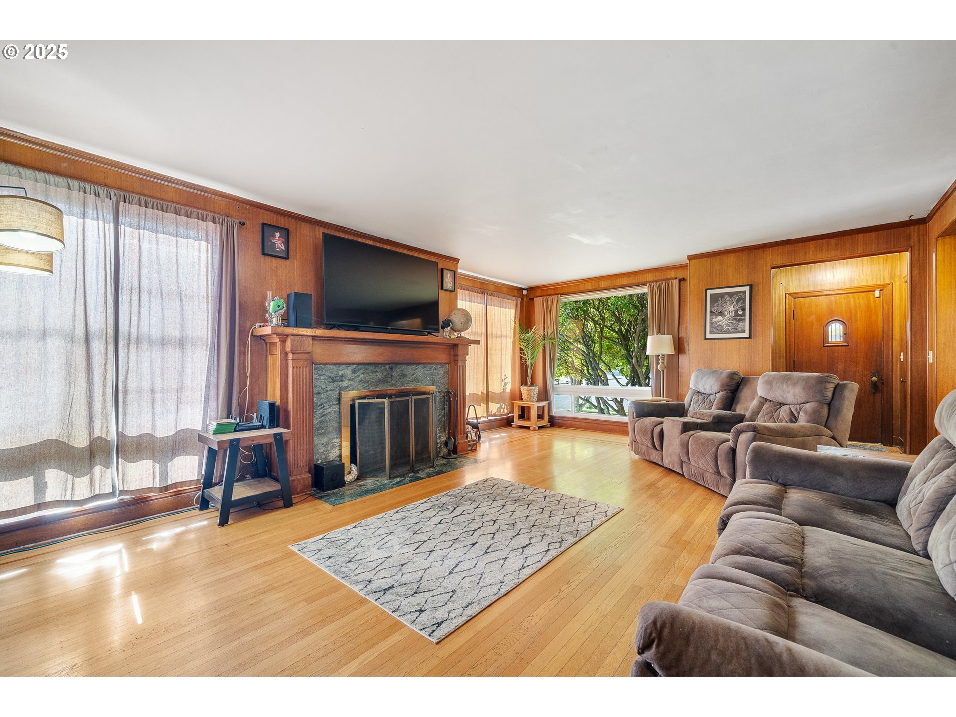 1703 4th Street Tillamook, OR 97141 - Photo 5 of 36 a living room with furniture a fireplace and a flat screen tv