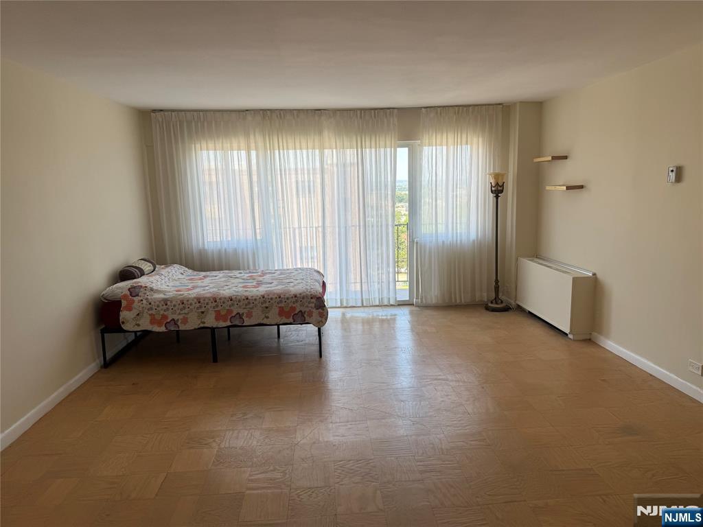 265 Main Street, Unit 702 Ridgefield Park, NJ 07660 - Photo 13 of 20 a spacious bedroom with a bed and a window